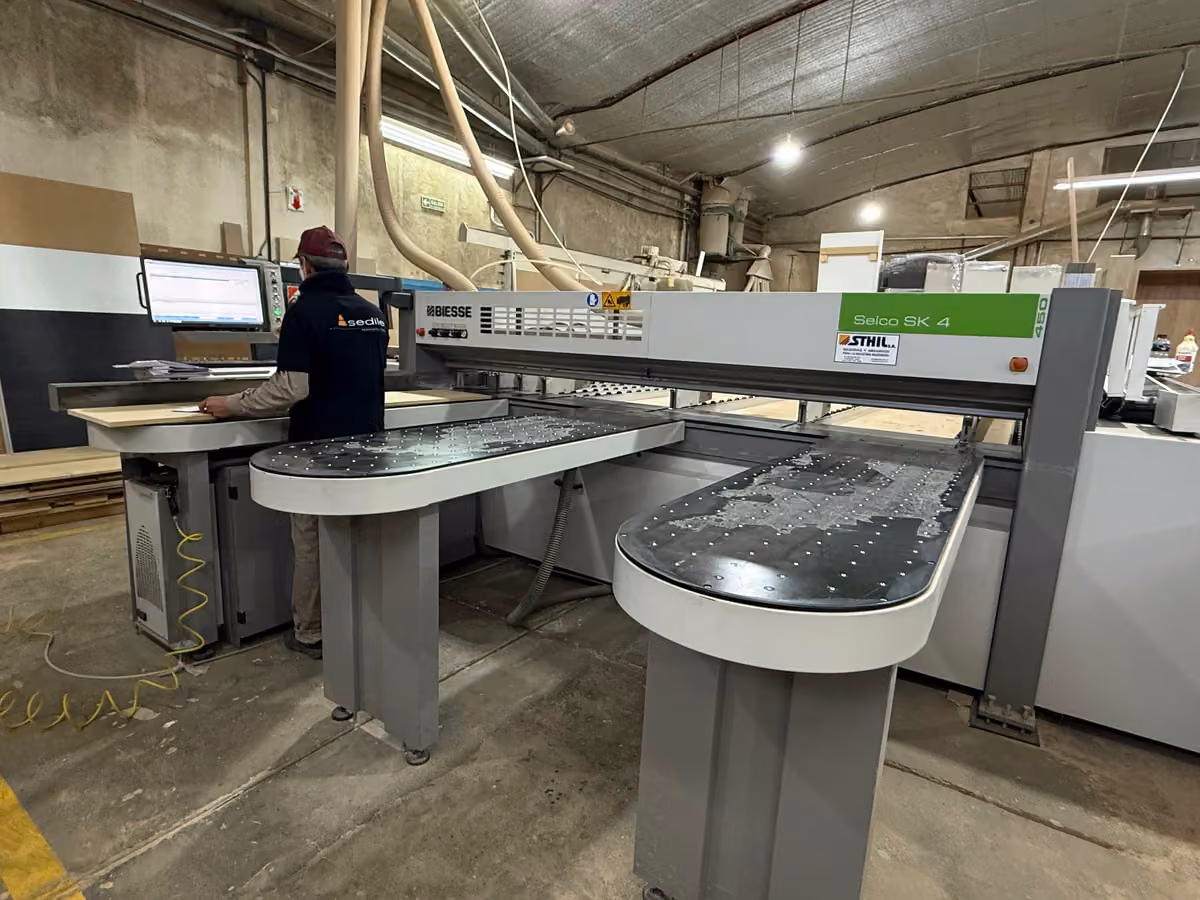 Operario de Sedile cortando tableros en la seccionadora Biesse Selco.